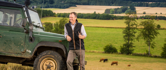 Farmer in field next to Land Rover